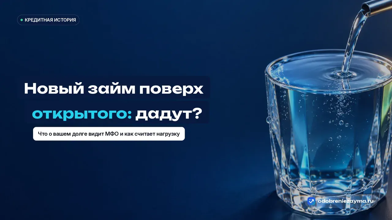 Башенка из плоских речных камней-голышей на тёмно-синей плите, сверху рука опускает ещё один камень — конструкция на самом пределе равновесия, метафора нового займа поверх непогашенного